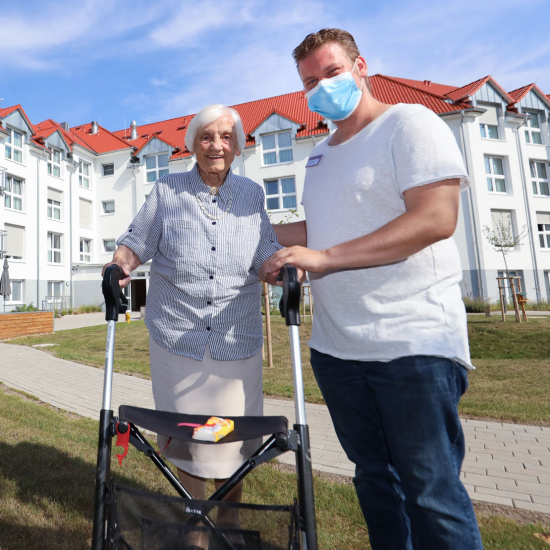 Ein Pfleger mit einer Bewohnerin