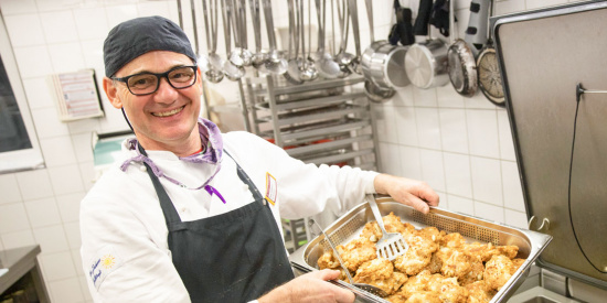 Ein Koch hält ein Tablett mit Essen