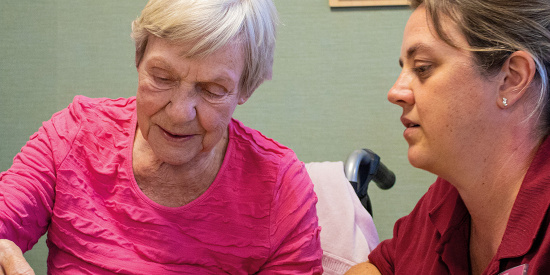 Mitarbeiterin und Bewohnerin beim Brettspiel